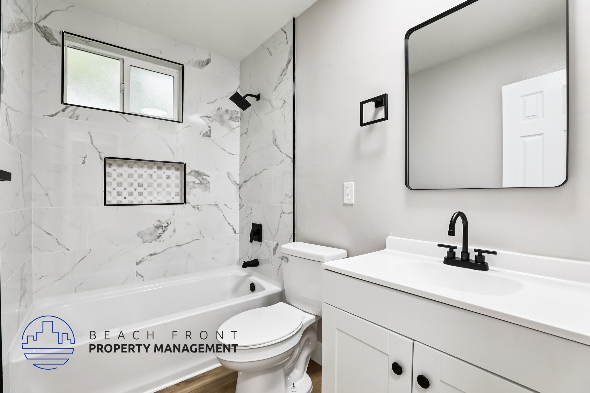A bathroom with a marble wall and a white sink.
